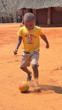 Kid playing football in local village in Zimbabwe